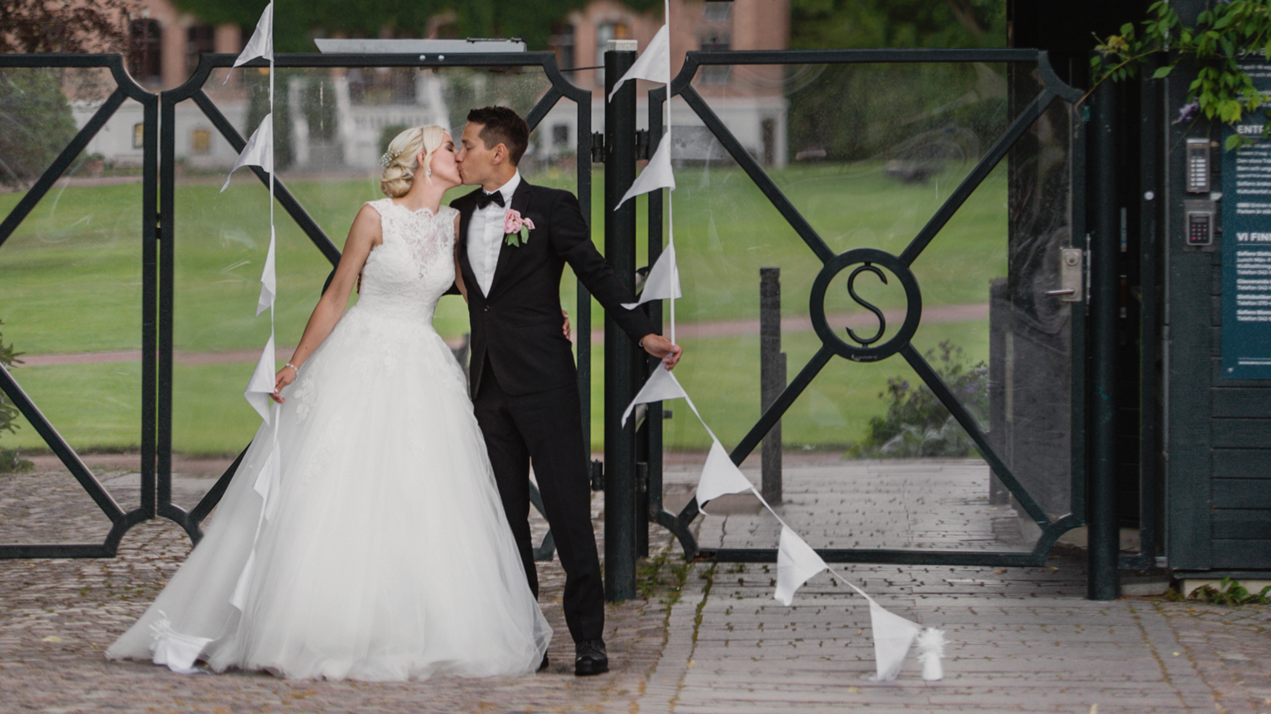 Bröllopspar kysser varandra utanför Sofiero entré.