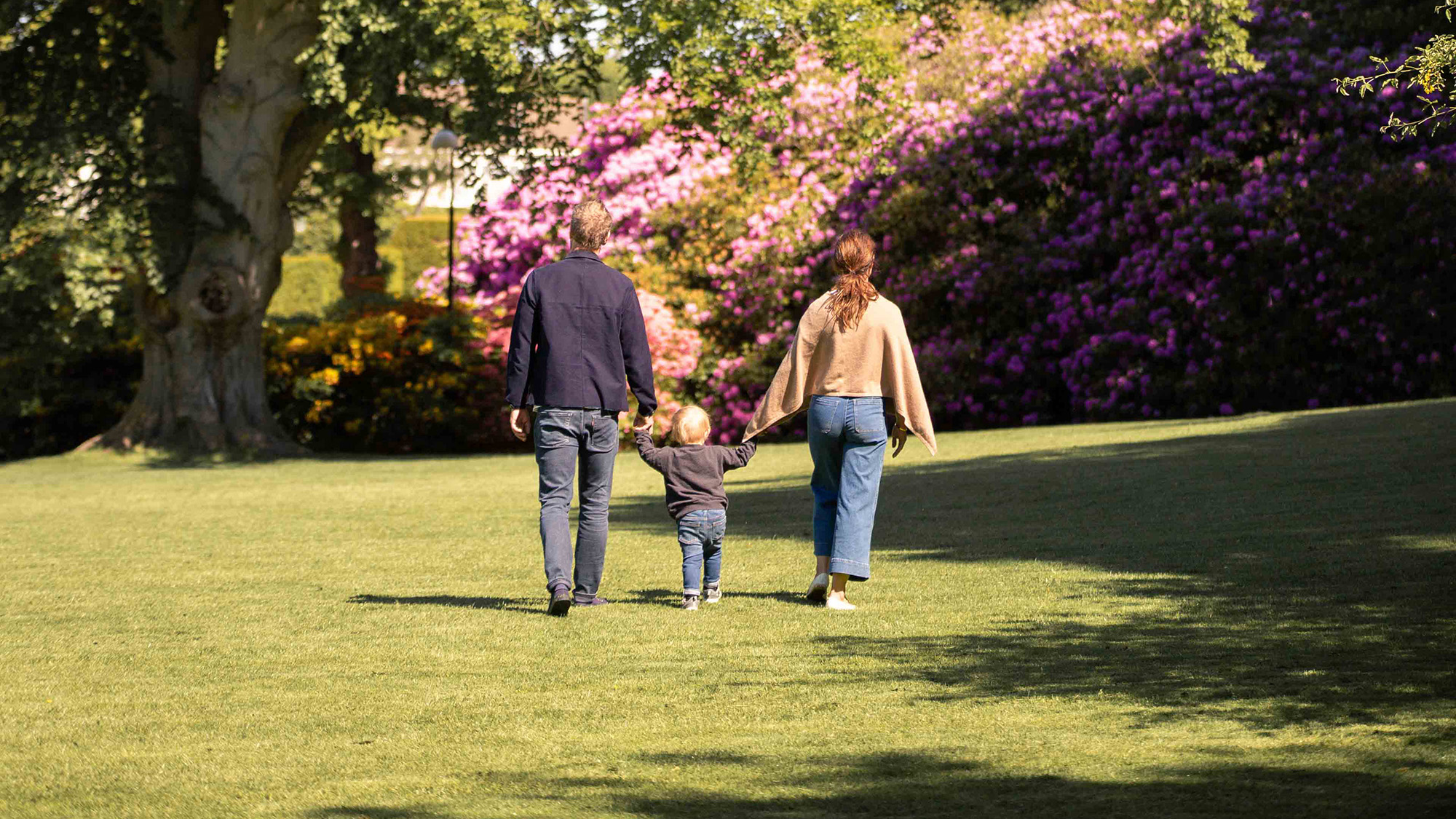Familj som håller hand i parken.