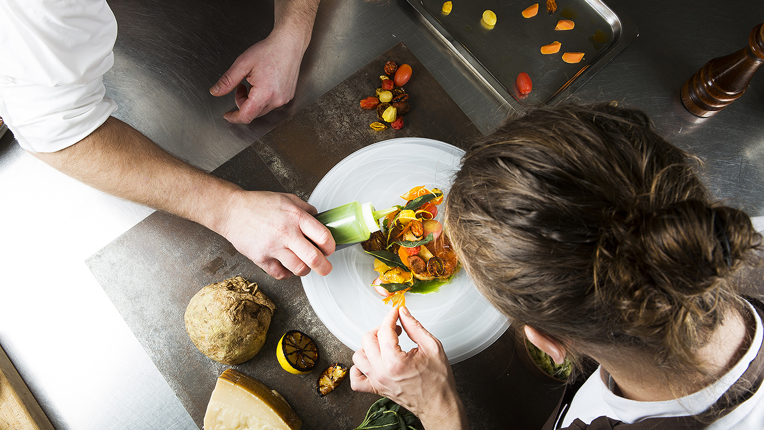 Kockar lägger upp mat på tallrik.